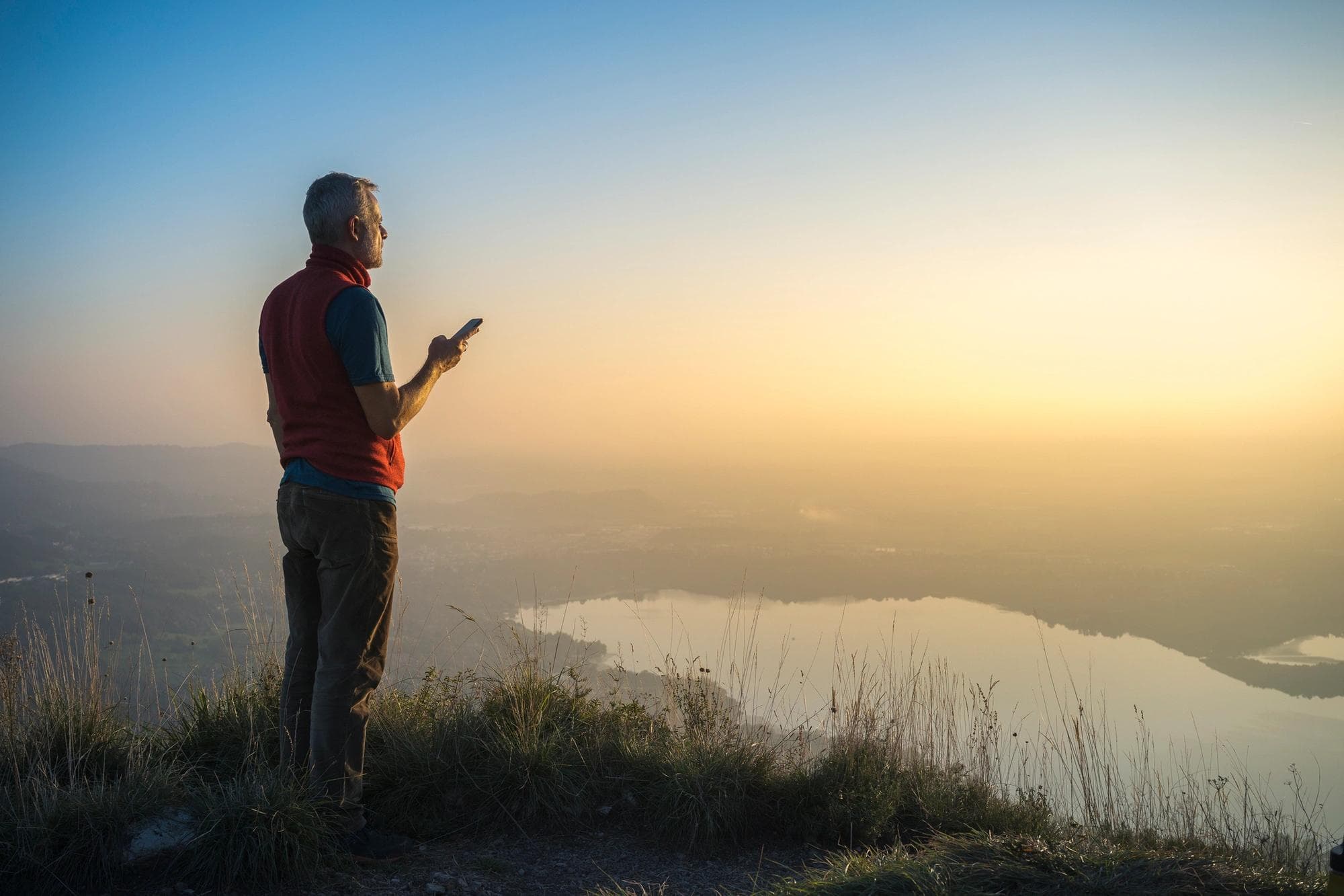  personne debout au sommet d’une colline au téléphone