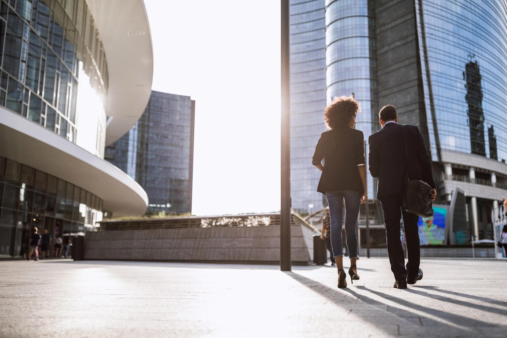 Un couple marche devant des immeubles de bureaux