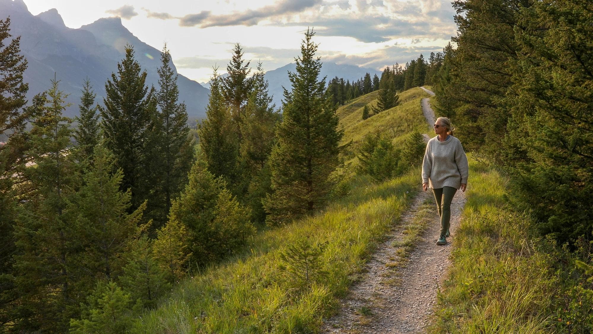 Une femme d'âge mûr descend un sentier le matin