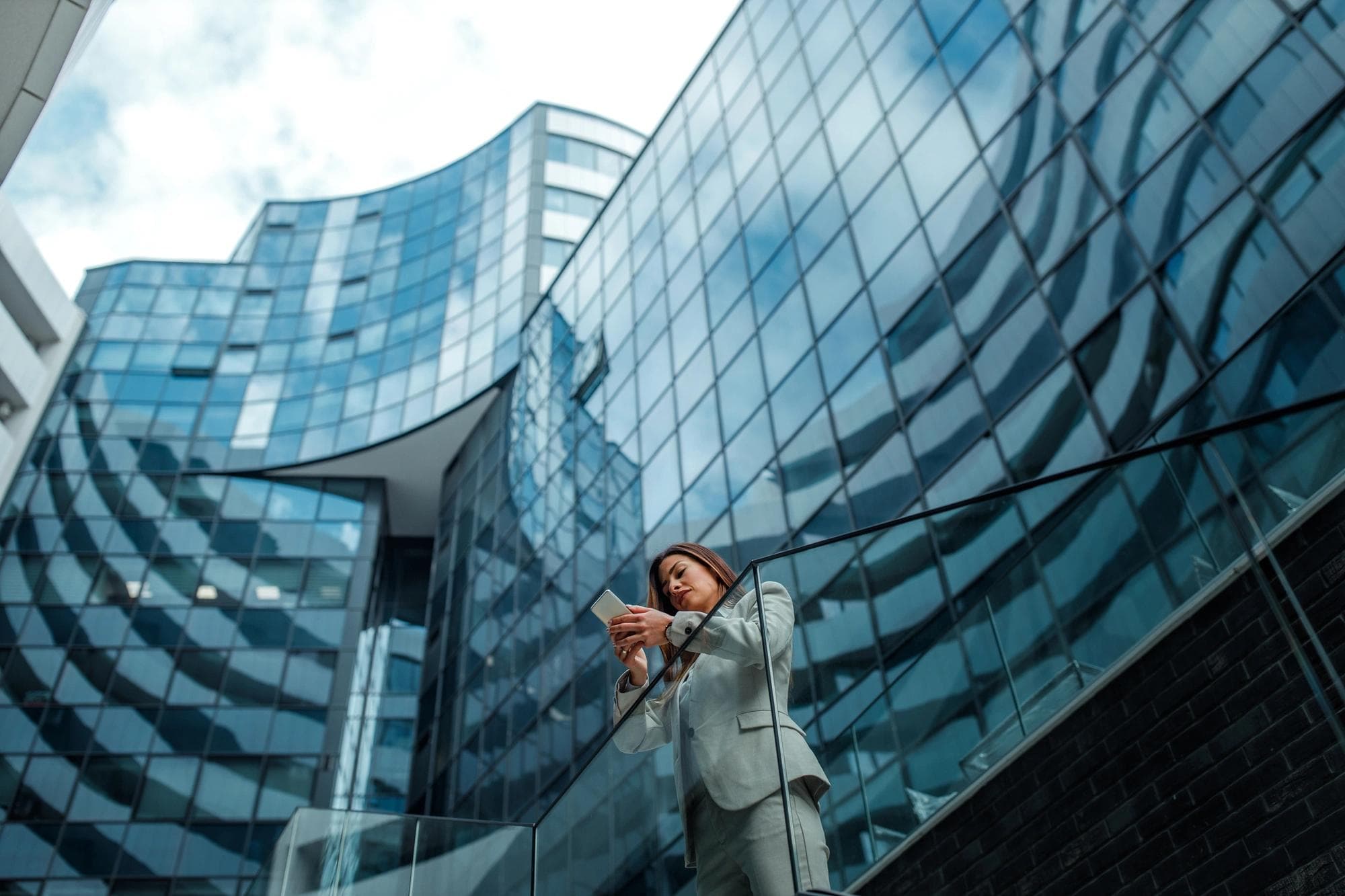 femme au téléphone debout devant l’immeuble de bureaux