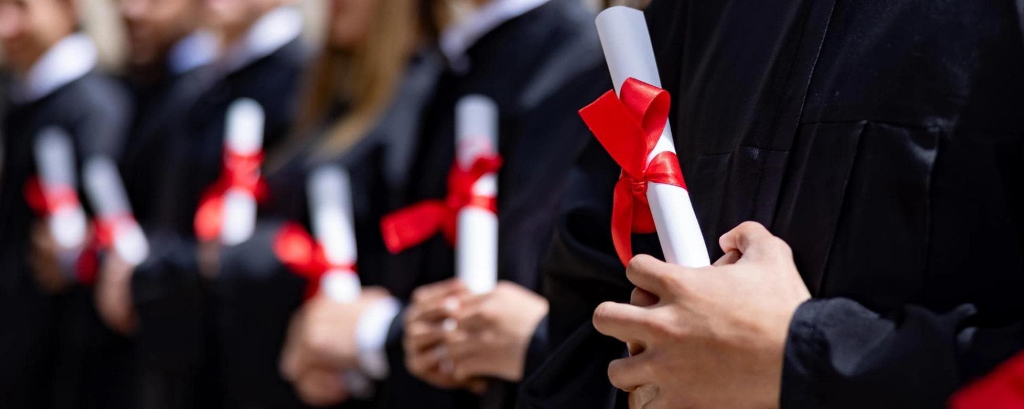 Étudiants diplômés détenant des parchemins de diplôme.