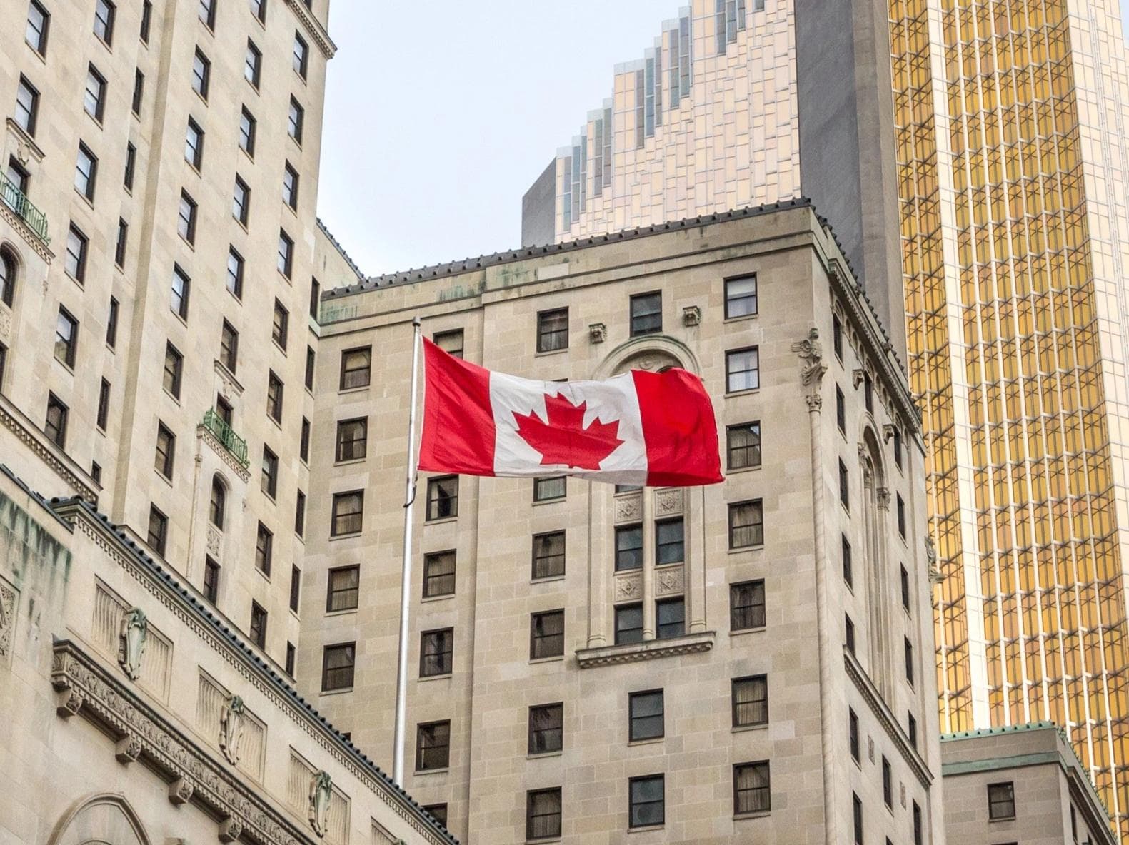 Drapeau canadien flottant devant un immeuble d’affaires à Toronto, en Ontario